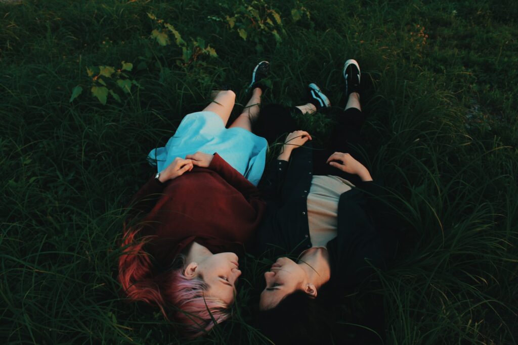 two women lying on grasses