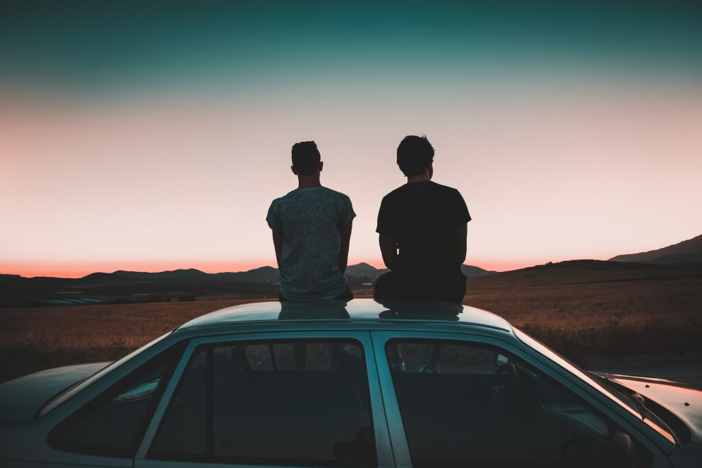 two men sitting on vehicle