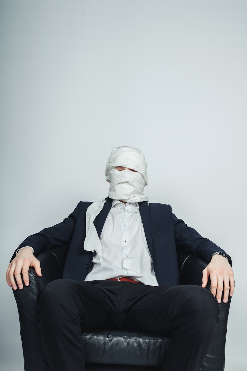 a man sitting in a chair with a mask on his face