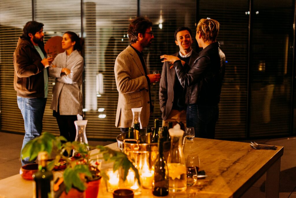 five person standing while talking each other at an office party